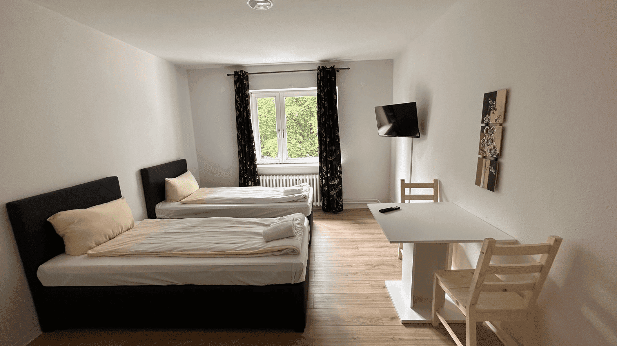 Monteurzimmer in Neumünster – hell eingerichtetes Zimmer mit Boxspringbett und Smart-TV